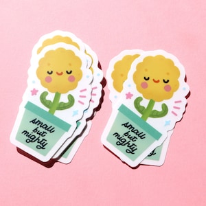 May include: A stack of five yellow flower stickers with green stems and a light green pot. The stickers have a smiling face and the text "small but mighty" on the pot.