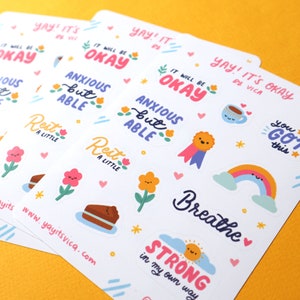 May include: A set of colorful stickers with positive affirmations and cute illustrations. The stickers feature phrases like "It will be okay", "Anxious but able", "Rest a little", "You got this", "Breathe", and "Strong in my own way".