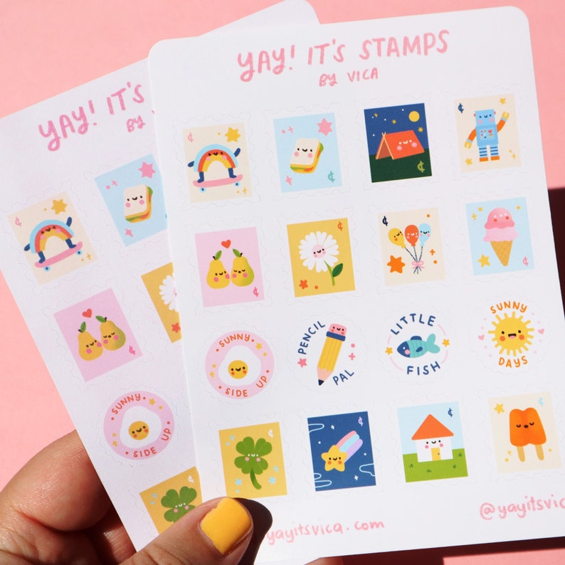 Pu&ograve; includere: Un set di adesivi colorati con illustrazioni carine di vari oggetti, tra cui un arcobaleno, un panino, una tenda da campeggio, un robot, una pera, una margherita, palloncini, gelato, una matita, un pesce, un sole, un quadrifoglio, una stella, una casa e un ghiacciolo. Gli adesivi sono disposti in una griglia su uno sfondo bianco. Il testo "YAY! IT'S STAMPS BY VICA" &egrave; stampato nella parte superiore del foglio. Il testo "yayitsvica.com" e "@yayitsvica" &egrave; stampato nella parte inferiore del foglio.