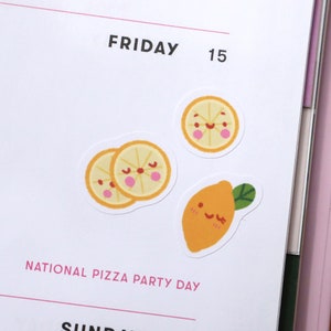 Puede incluir: Una p&aacute;gina de planificador con el texto "FRIDAY 15" y el texto "NATIONAL PIZZA PARTY DAY". Hay tres pegatinas de lim&oacute;n amarillo con caras sonrientes.