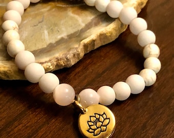 Bracciale con perline bianche e ciondolo a forma di fiore di loto dorato