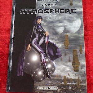 以下が含まれることがあります： 白黒の表紙に、白い文字で「SINKHA ATMOSPHERE」というタイトルが書かれている。表紙には、紫と黒の服を着た女性が大きな銀色の球体の上に座っている。背景は雲の多い空で、構造物が浮かんでいる。