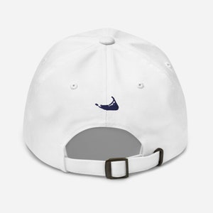Può includere: Cappellino da baseball bianco con un contorno di un'isola ricamato in blu navy sul retro.