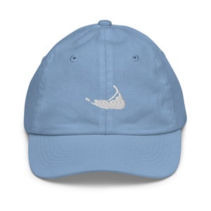 Può includere: Un berretto da baseball blu chiaro con un contorno di un'isola ricamato in bianco.