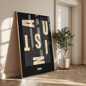 May include: A framed black and gold poster with the word "AUSTIN" in large, bold, cream-colored letters. The letters are stacked vertically and overlay a detailed text about Austin, Texas. The poster is leaning against a wall next to a potted plant.