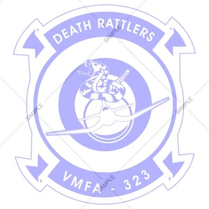 May include: A light purple emblem featuring the text "DEATH RATTLERS" and "VMFA-323". The emblem includes a coiled rattlesnake above a stylized airplane within a circular design. The design is set against a white background.
