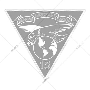 May include: A grey triangular patch with a white eagle holding a globe in its talons. The patch has the text "Marine Aircraft Group 13" around the eagle and globe.