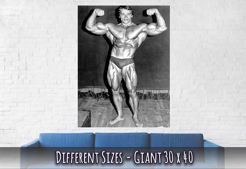 Op de afbeelding: Zwart-witfoto van een bodybuilder die zijn biceps aanspant. De foto is afgedrukt op een poster met de tekst "DIFFERENT SIZES - GIANT 30 x 40".