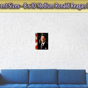May include: A poster featuring a portrait of Ronald Reagan, the 40th President of the United States. He is wearing a suit and tie, and standing in front of an American flag. The poster is 8 inches by 10 inches.