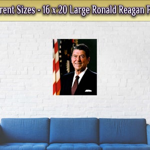 May include: A large poster featuring a portrait of Ronald Reagan, the 40th President of the United States. The poster is 16 x 20 inches and features a close-up of Reagan in a suit and tie, with the American flag in the background.