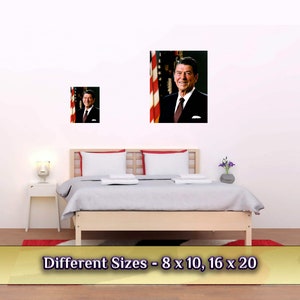 May include: A framed photograph of Ronald Reagan, the 40th President of the United States, standing in front of an American flag. The image is displayed on a white wall above a bed with white bedding. The text "Different Sizes - 8 x 10, 16 x 20" is displayed below the image.