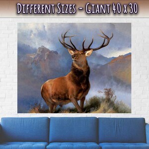 Peut inclure: Une peinture repr&eacute;sentant un grand cerf brun aux bois debout dans un paysage montagneux brumeux. Le cerf regarde vers la gauche et les montagnes sont en arri&egrave;re-plan. La peinture est intitul&eacute;e "Different Sizes - Giant 40 x 30".