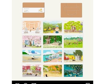 May include: A set of 12 illustrated postcards featuring scenes of Japanese life. The postcards are arranged in a grid of four rows and three columns. Each postcard depicts a different scene, such as a cherry blossom tree, a temple, a train station, and a beach. The postcards are all in a cartoon style and feature a black cat character.