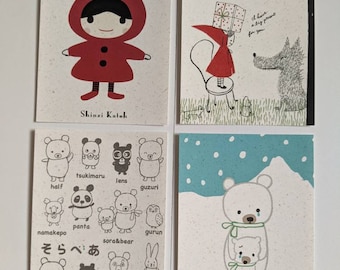 May include: Four illustrated postcards featuring cute animal characters and the text "Shinzi Katoh". The first postcard shows a girl in a red hooded cloak. The second postcard shows a wolf and a girl carrying a gift. The third postcard shows a variety of animals including a panda, a bear, a rabbit, and a seal. The fourth postcard shows two polar bears with a snowy background.