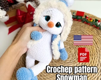 May include: Crocheted snowman amigurumi pattern in PDF format. The pattern includes instructions for making a white snowman with blue accents, wearing a white fur-trimmed hat. The pattern is available for download.