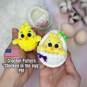 May include: Crochet pattern for a "Chicken in the Egg" amigurumi. The pattern is available as a PDF download. The image shows two crocheted chicks, one in a white egg and one outside the egg. Both chicks are yellow with black eyes and orange beaks.
