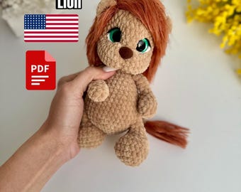 May include: Crochet pattern for a lion amigurumi toy. The lion is brown with a red mane and tail. The pattern is available as a PDF download.