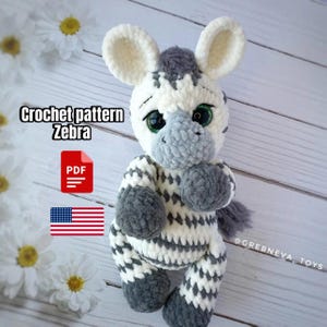 Może przedstawiać: Wzór na szydełku na zabawkę amigurumi w kształcie zebry. Zebra jest biała i szara w czarne paski i ma duże zielone oczy. Wzór jest dostępny do pobrania w formacie PDF. Obraz zawiera również tekst "Crochet pattern Zebra" i flagę USA.