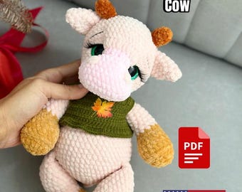Puede incluir: Patrón de crochet para un juguete amigurumi de vaca rosa y marrón. El juguete lleva un chaleco de crochet verde con un diseño de hoja. El patrón está disponible para descargar en PDF. Patrón de crochet Vaca.