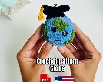 May include: A crocheted globe with blue and green yarn, wearing a black graduation cap with a yellow tassel. The text "Crochet pattern Globe" is displayed below the globe, along with a PDF icon and an American flag.