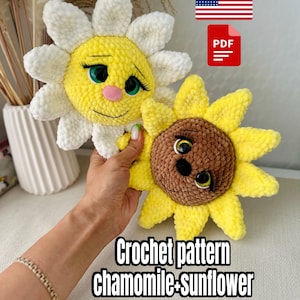 May include: Two plush crochet flowers, a daisy and a sunflower, are held in a person's hand. The daisy has white petals and a yellow center with a smiling face. The sunflower has yellow petals and a brown center. Text reads "Crochet pattern chamomile+sunflower".