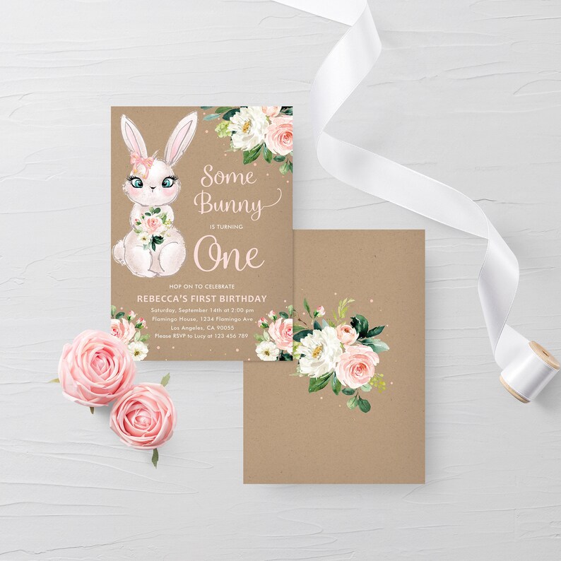 May include: A brown and white bunny rabbit with pink flowers in its paws. The bunny is wearing a pink headband with a white bow. The text "Some Bunny is turning One" is written in pink and white lettering. The background is a brown kraft paper with a floral design.