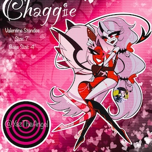 May include: A Valentine's Day standee featuring the characters Chaggie, with a size of 7 inches and a base size of 4 inches. The artwork depicts two characters embracing, set against a pink background with heart patterns. The standee has a circular logo with the text "@YazTheAngel".
