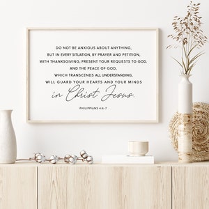 Puede incluir: Una impresi&oacute;n enmarcada con el texto "No se preocupen por nada...en Cristo Jes&uacute;s. Filipenses 4:6-7". La impresi&oacute;n est&aacute; en un marco de madera clara, exhibida en un mueble de madera clara con jarrones decorativos y un mantel individual tejido.