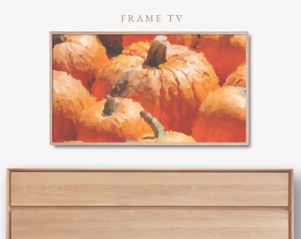May include: A framed artwork featuring a close-up of several orange pumpkins. The pumpkins have textured surfaces and green stems. The artwork is displayed above a light-colored wooden dresser. The text "FRAME TV" is at the top.