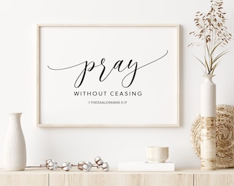 May include: A framed print with the text "pray without ceasing 1 Thessalonians 5:17" in black cursive script on a white background.