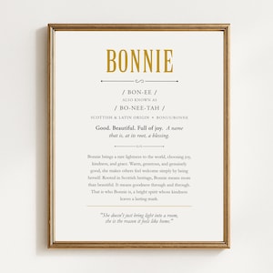 May include: A framed wall print featuring the name BONNIE in gold text, followed by phonetic pronunciations, origin details, and a descriptive paragraph defining the name as good, beautiful, and full of joy, ending with a quote about bringing light.
