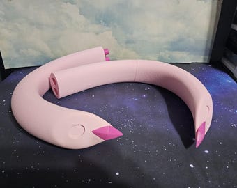 May include: A light pink, curved sculpture resembling a swan's neck and head. The beak is a darker pink, and the sculpture has a smooth, matte finish. The swan sculpture is placed on a starry background.