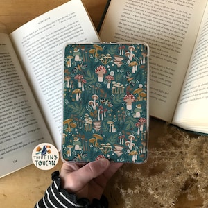 May include: A teal blue e-reader cover featuring a mushroom and snail pattern. The cover is made from a durable material and has a clear plastic overlay.