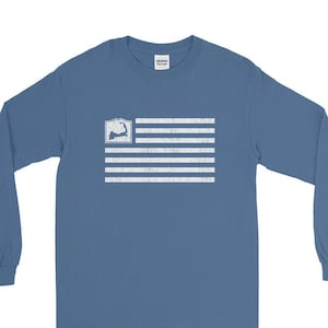 May include: A long-sleeved t-shirt in a blue denim color with a white distressed American flag design featuring the outline of Cape Cod.