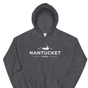 May include: A dark gray hooded sweatshirt with a white graphic design featuring the text "NANTUCKET MASS" and a stylized outline of an island. The text "INC. 1671" is also included in the design.
