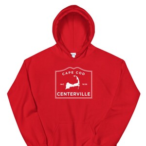 May include: Red hooded sweatshirt with a white graphic of a vintage logo for Cape Cod, Inc. 1639 Centerville.