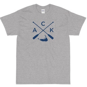 Könnte beinhalten: Graues T-Shirt mit einem marineblauen Aufdruck von gekreuzten Rudern und den Buchstaben "C A K" mit einer Silhouette einer Insel in der Mitte.