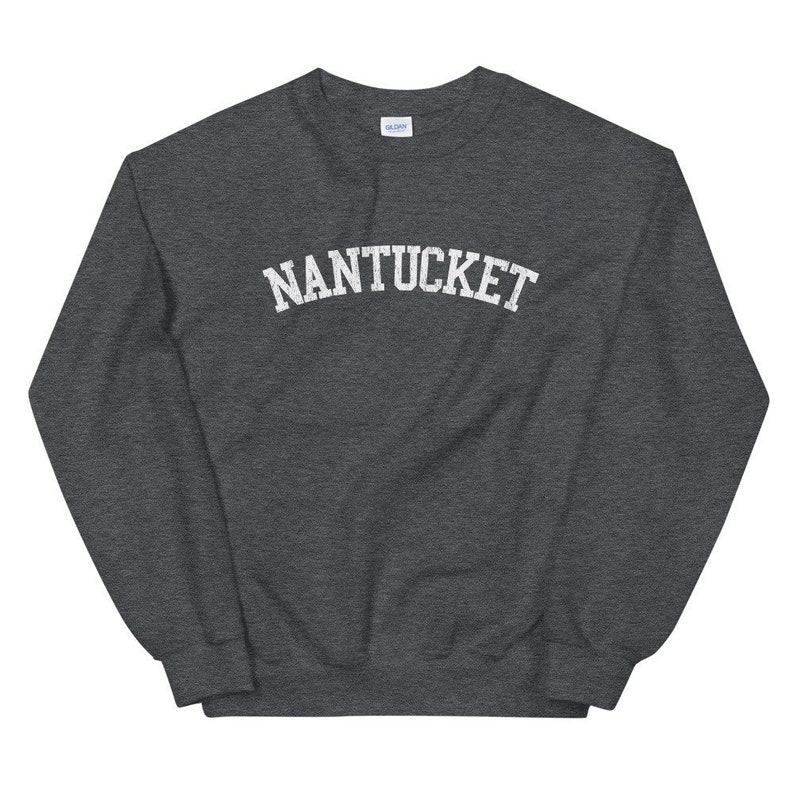 May include: Dark gray sweatshirt with the word "NANTUCKET" printed in white, arched across the chest. The sweatshirt has a crew neck and long sleeves. The fabric appears to be a soft, comfortable material.