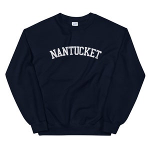 May include: Navy blue sweatshirt with the word "NANTUCKET" printed in white, arched lettering. The sweatshirt has a crew neck and long sleeves. The fabric appears to be a soft, comfortable material.