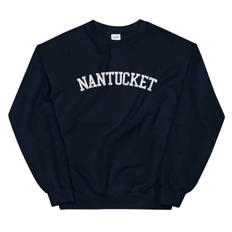 May include: Navy blue sweatshirt with the word "NANTUCKET" printed in white, arched lettering. The sweatshirt has a crew neck and long sleeves. The fabric appears to be a soft, comfortable material.
