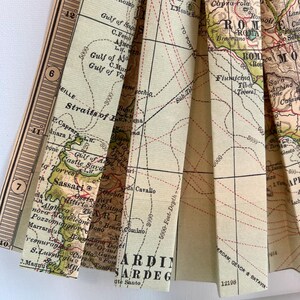 Puede incluir: Un mapa vintage de Italia y Cerde&ntilde;a, doblado en forma de abanico. El mapa est&aacute; impreso en papel color crema con l&iacute;neas y texto marrones y rojos. El mapa muestra las ciudades de Roma, Florencia y N&aacute;poles, as&iacute; como la isla de Cerde&ntilde;a.