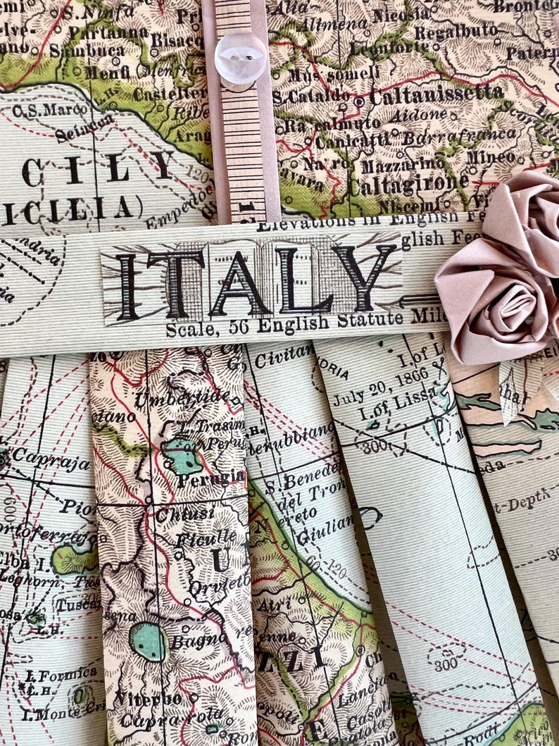 Puede incluir: Un mapa vintage de Italia con la palabra "ITALIA" impresa en negro sobre una pancarta beige. El mapa est&aacute; doblado y muestra varias regiones de Italia, incluyendo Umbr&iacute;a, Perugia y Toscana. El mapa est&aacute; impreso en papel color crema con l&iacute;neas verdes y marrones.