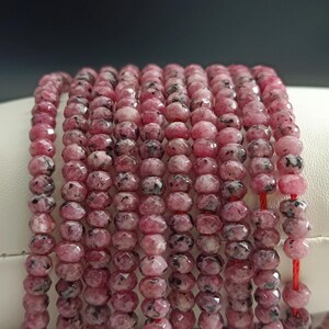 Peut inclure: Un brin de perles de pierres précieuses roses et noires. Les perles sont facettées et ont un aspect moucheté.