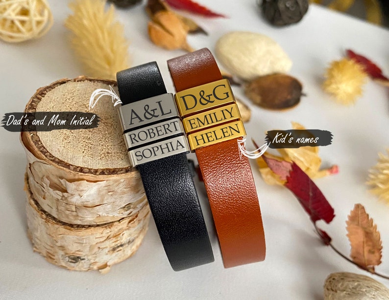 Puede incluir: Dos pulseras de cuero con abalorios de metal personalizados. La pulsera negra tiene las iniciales "A&L" y los nombres "Robert" y "Sophia". La pulsera marr&oacute;n tiene las iniciales "D&G" y los nombres "Emily" y "Helen".