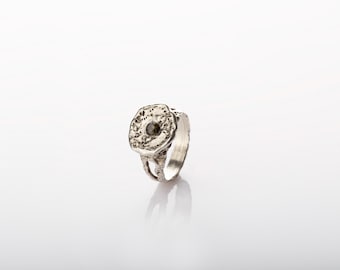 A unique silver ring set with a brownish-green tourmaline crystal