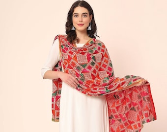 May include: A red, green, and pink patterned dupatta with gold trim. The dupatta is made of a lightweight fabric and has a geometric design.