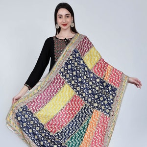 Könnte beinhalten: Ein farbenfroher Patchwork-Dupatta mit einer dunkelblauen Basis und goldener Stickerei. Der Dupatta hat einen Rand aus silbernen und goldenen Pailletten.