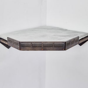 May include: A hexagonal corner shelf with a white marble top and a dark brown wood frame. The frame has a decorative metal trim with a slatted design.