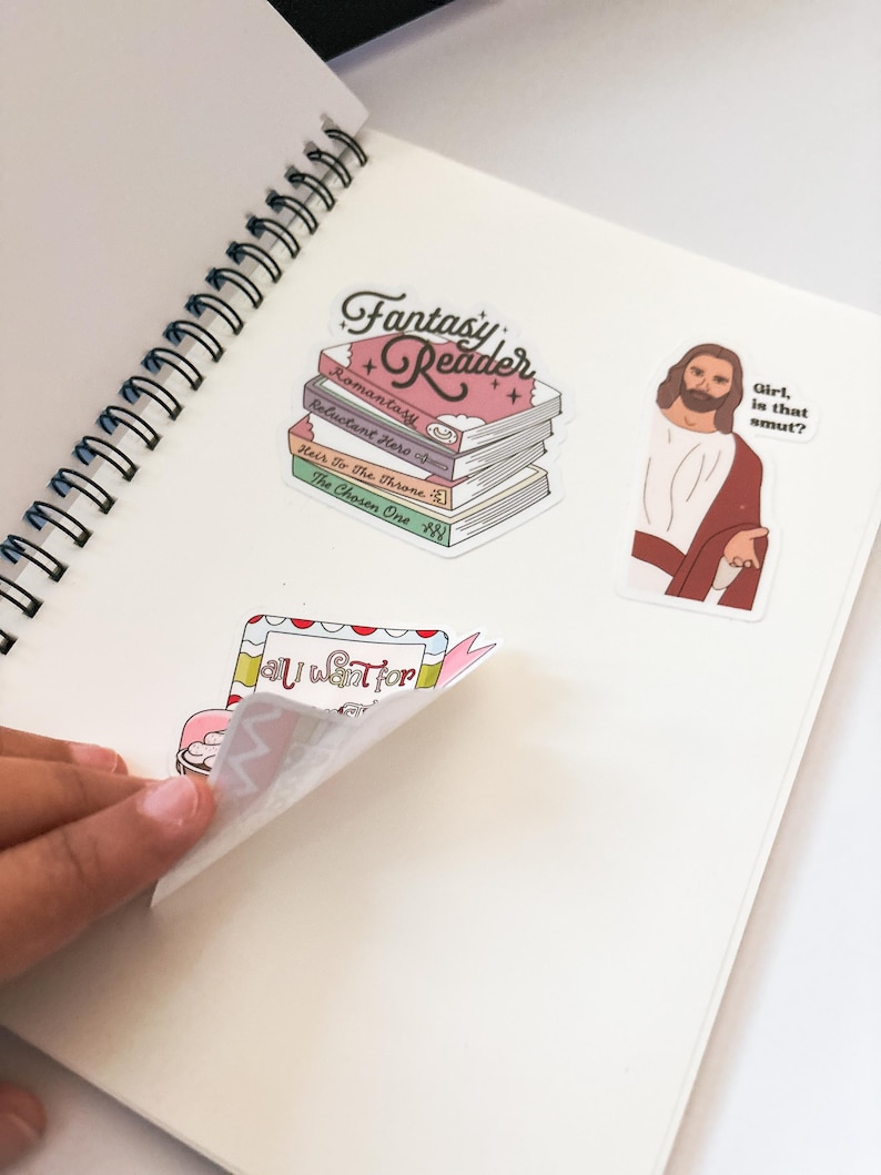 a person is holding a book with stickers on it