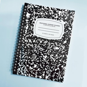 K&ouml;nnte beinhalten: Ein spiralgebundenes Notizbuch mit einem klassischen schwarz-wei&szlig; gesprenkelten Einband. Das wei&szlig;e Etikett auf der Vorderseite tr&auml;gt den Text EMOTIONAL SUPPORT STICKERS COMPOSITION BOOK, 50 SHEETS 100 PAGES sowie zwei horizontale Linien.